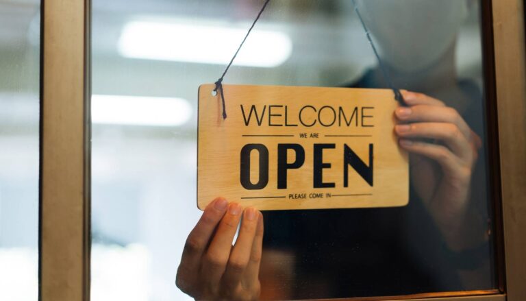 Znak 'Otvoreno' okačen na vrata, najavljujući dostupnost i spremnost preduzeća.