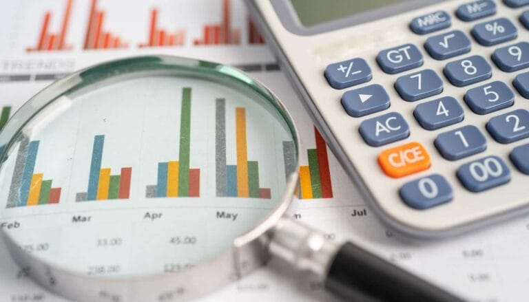 Povećani prikaz kroz lupu na grafikon i kalkulator, simboli za analizu podataka i finansijsko planiranje.