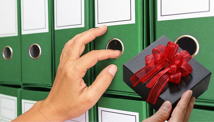 registratori za knjigovodstvo i ruka koja drži paketić za decu