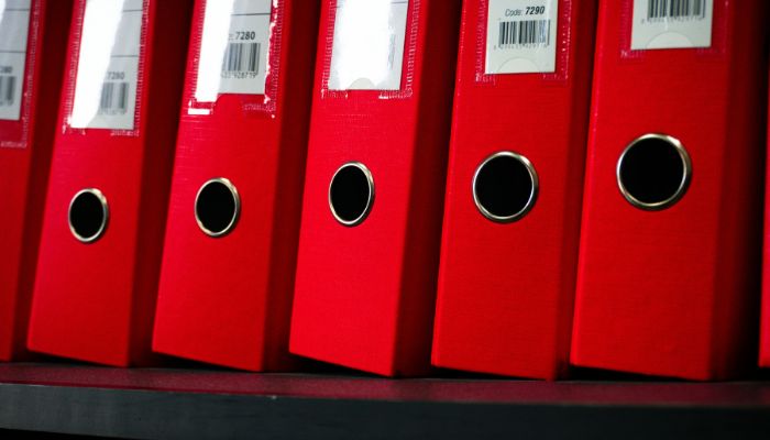 Crveni registratori sa finansijskom dokumentacijom kao simbol urednog knjigovodstva i računovodstvenih usluga za firme u Beogradu