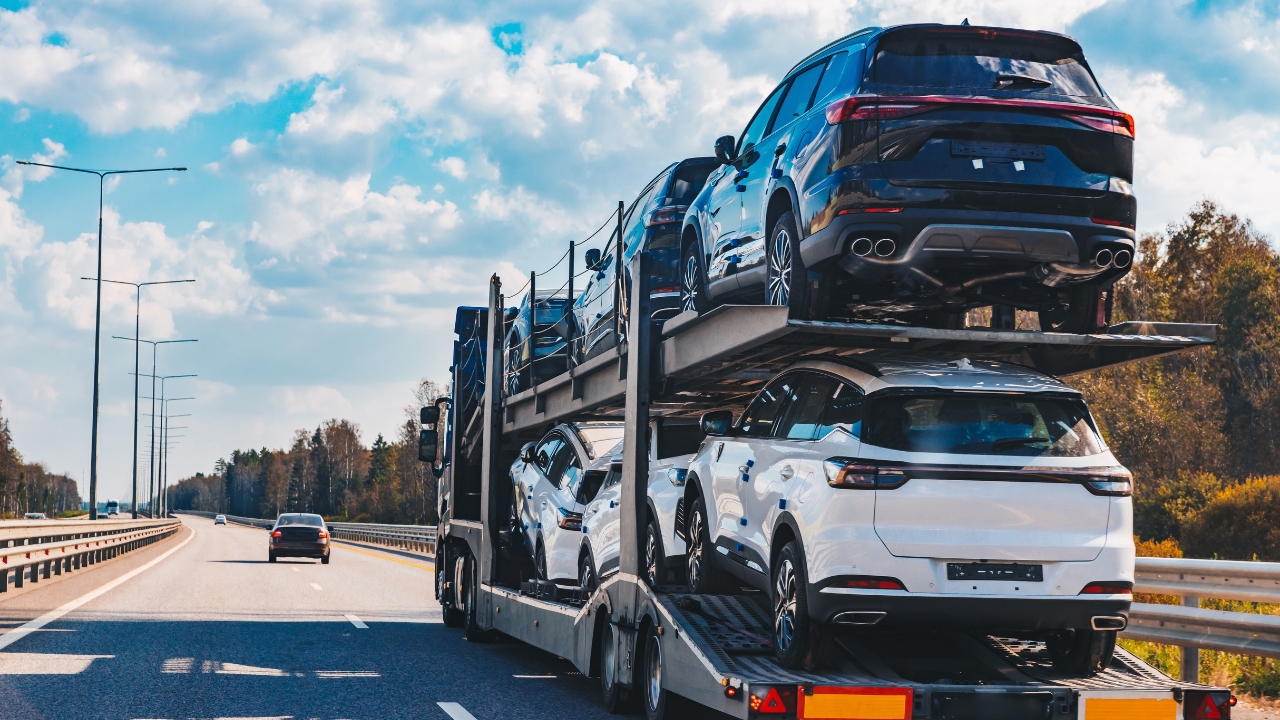 Kamion za prevoz automobila vozi autoputem sa više vozila natovarenih na prikolici