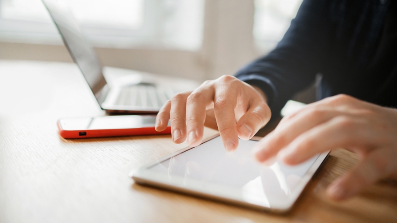 Osoba koristi tablet i laptop za praćenje troškova i obaveza vezanih za poslovanje preduzetničke radnje