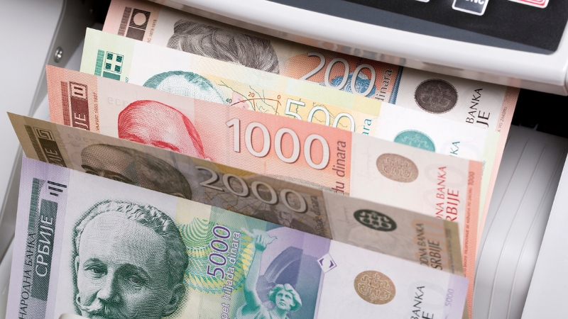 Novčanice dinara pored kalkulatora koje simbolizuju refundaciju troška koji je vlasnik firme platio ličnim novcem