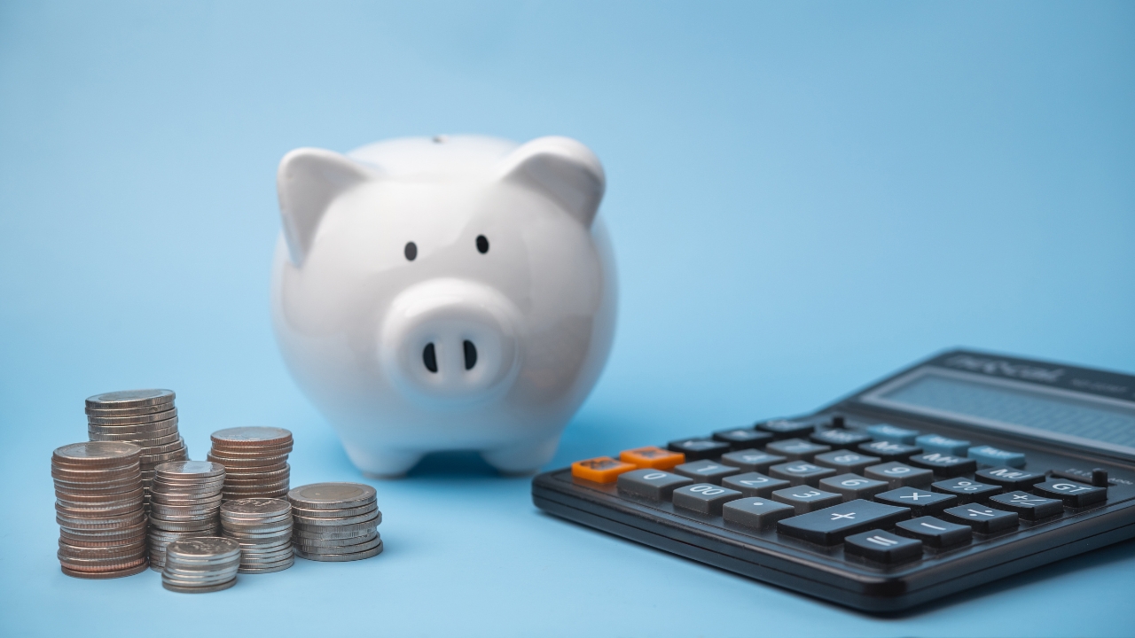 Kasica prasica, novčići i kalkulator prikazuju planiranje zarade i troškova