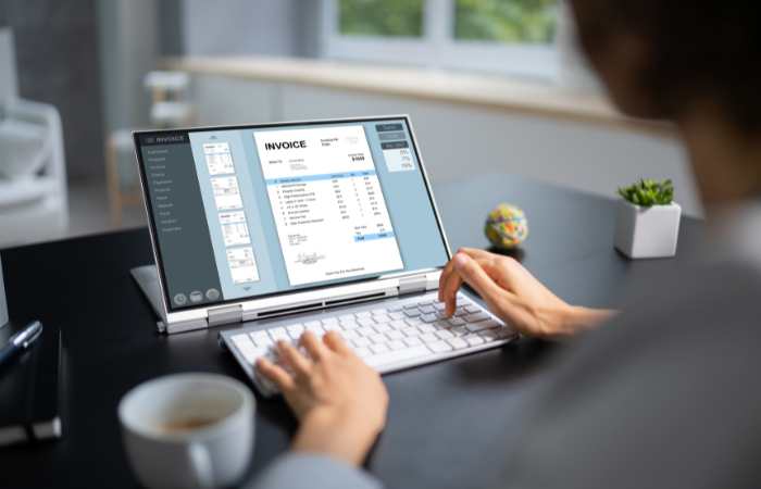 Čovek kuca na laptopu fakturu