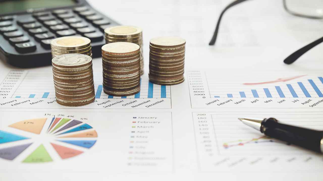 Šifre plaćanja za firme – digitron, novčići, olovka i finansijski grafikoni